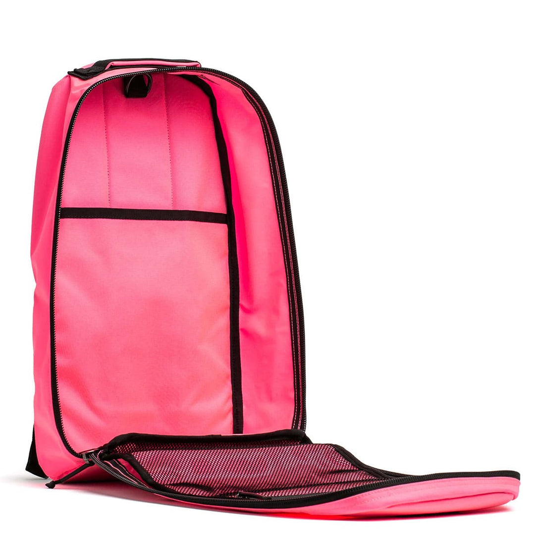 Displayed upright, the GORUCK Bullet Ruck - Classic in open pink with black trim offers interior compartments, making it perfect for rucking.