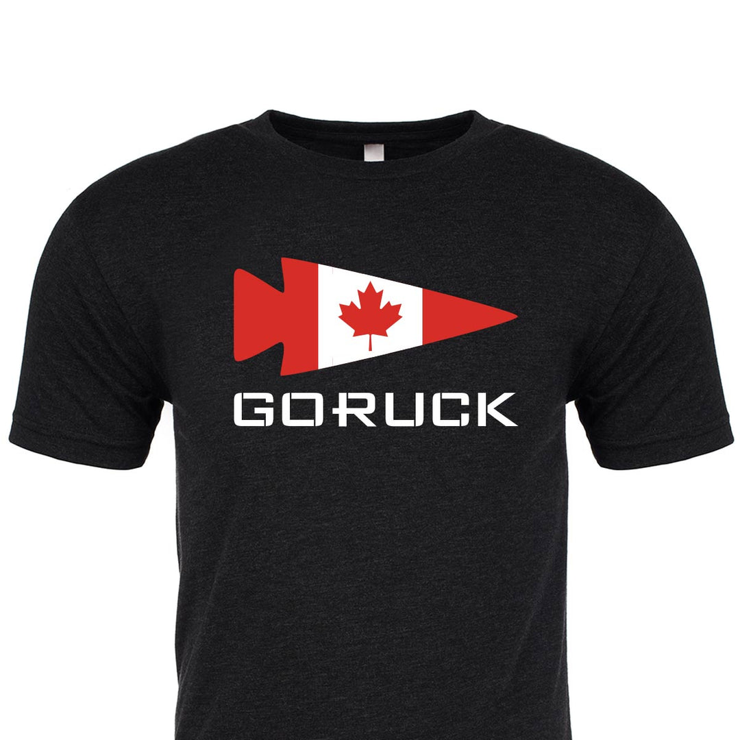 This premium tri-blend black t-shirt from GORUCK EU features a striking red arrow with a Canadian flag, along with the word "GORUCK" elegantly printed beneath it. This is the "Rep Your Country" edition.