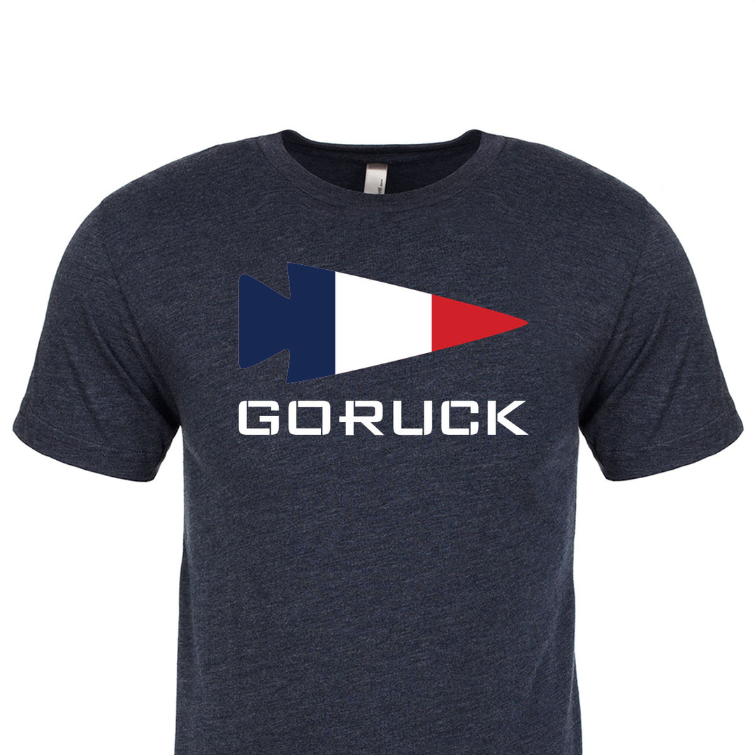 Introducing the Rep Your Country t-shirt from GORUCK EU, a premium tri-blend in dark gray adorned with a tricolor arrow logo and the elegantly displayed word "GORUCK" beneath it.