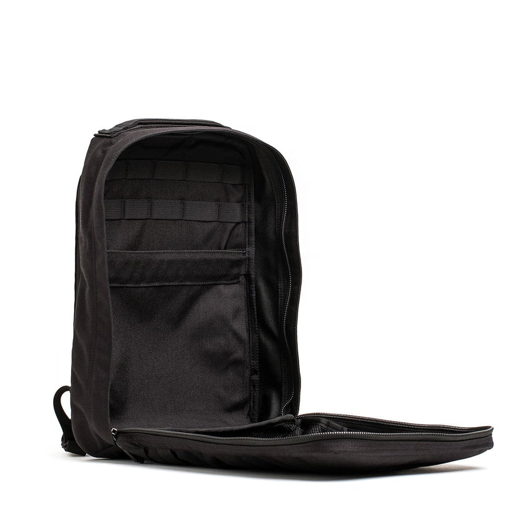 The GR0 - Cordura by GORUCK in black showcases an organized interior with mesh pockets and straps when its main compartment is unzipped. This minimalist EDC design includes a bombproof laptop compartment for efficient storage and accessibility.