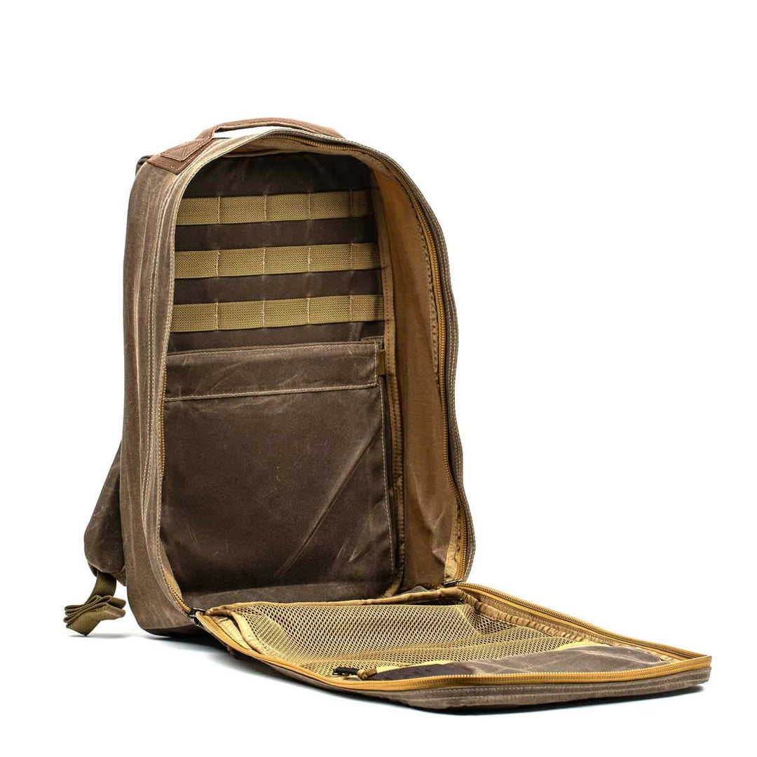 Discover the GR1 USA - Heritage by GORUCK, an open brown rucksack crafted from waxed duck canvas. This durable and stylish bag features multiple compartments and a mesh pocket on the flap, making it perfect for any adventure.
