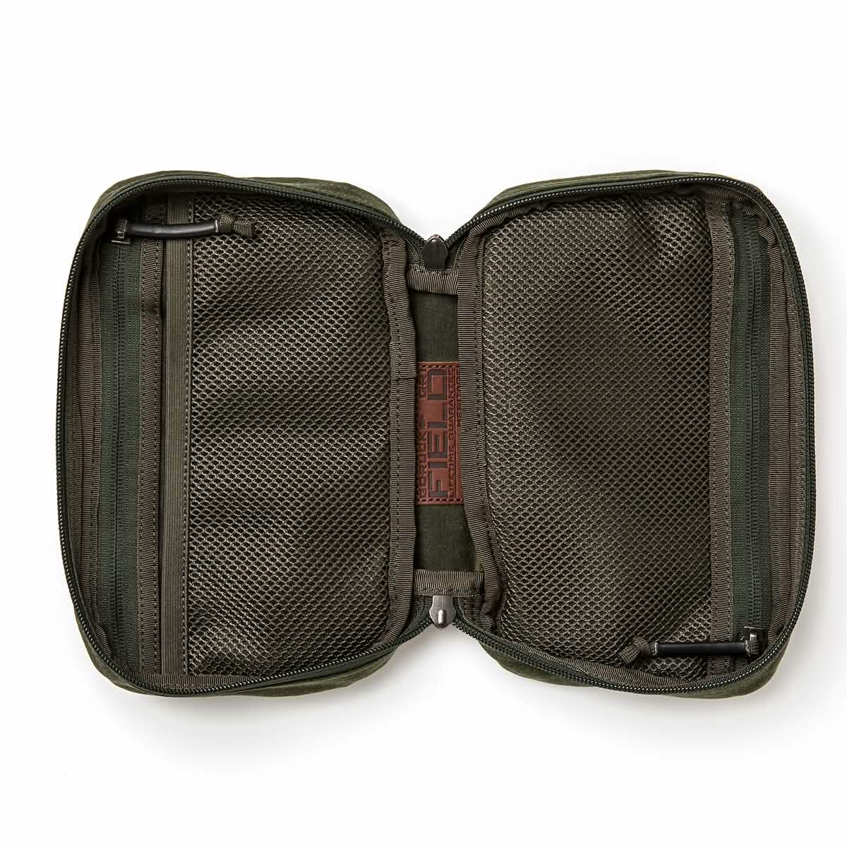 The GORUCK GR1 Field Pocket - Waxed Canvas is shown open and lying flat on a white background, revealing mesh zippered pockets on both sides—echoing the durable organization and classic styling of heritage field gear.