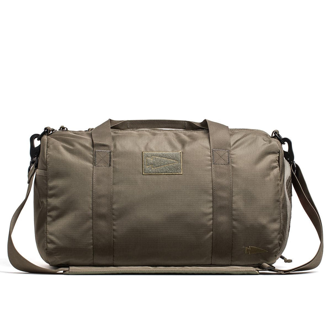 The GORUCK Gym Bag - Ripstop ROBIC® is a khaki-colored gym bag crafted from durable ripstop nylon, equipped with a shoulder strap, handles, and a convenient shoe compartment, displayed on a white background.