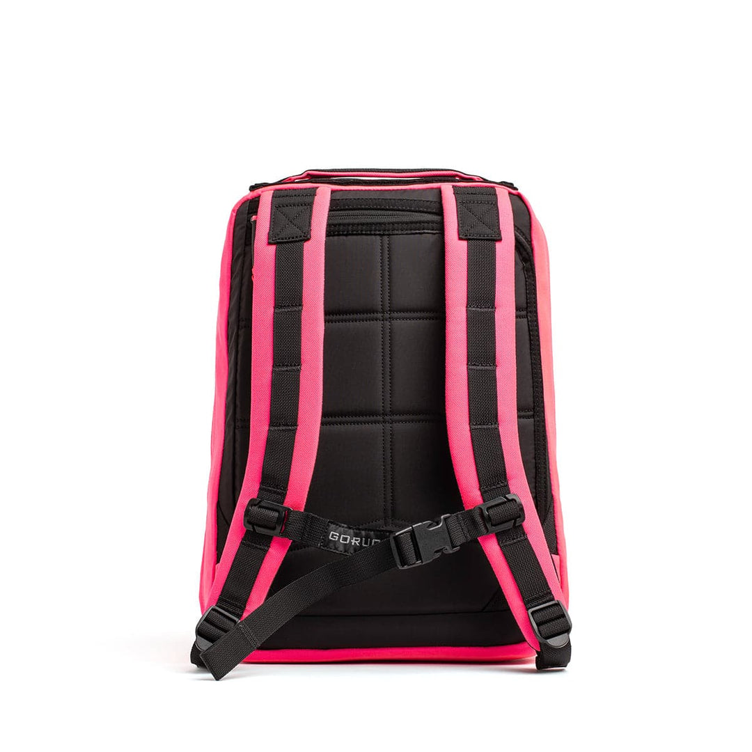 A black and pink compact backpack with padded shoulder straps and a top handle, featuring reinforced straps and back panel for comfort and support. It includes a bombproof laptop compartment, with the brand name GORUCK displayed at the lower back section of the GR0 - Cordura model.