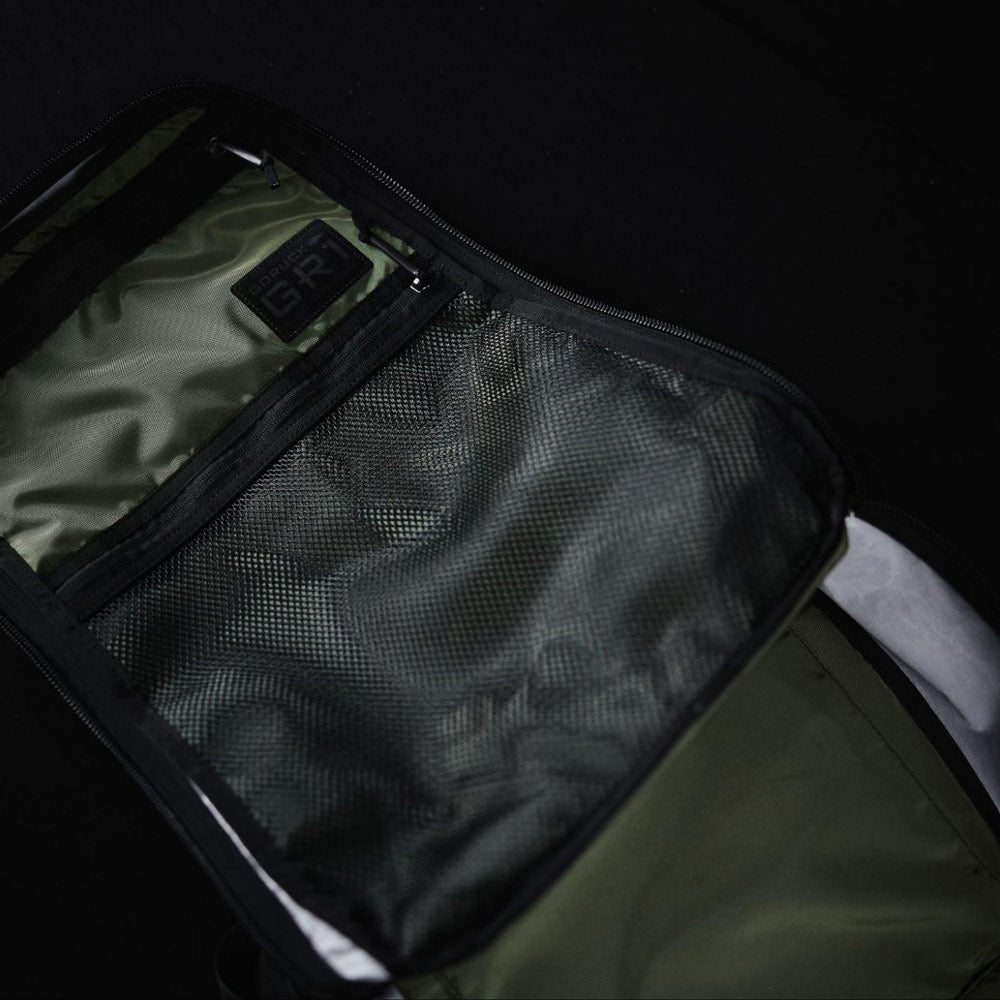 A close-up of an open backpack showing mesh and fabric pockets inside.