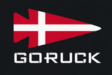 The Patch - Denmark by GORUCK features a red arrowhead with a white cross, resembling Denmark’s flag, above the brand name “GORUCK” on a black background.