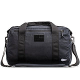 The Kit Bag - Waxed Canvas by GORUCK is a black duffel bag featuring short handles and a detachable shoulder strap, inspired by the classic Aviator's Kit Bag.