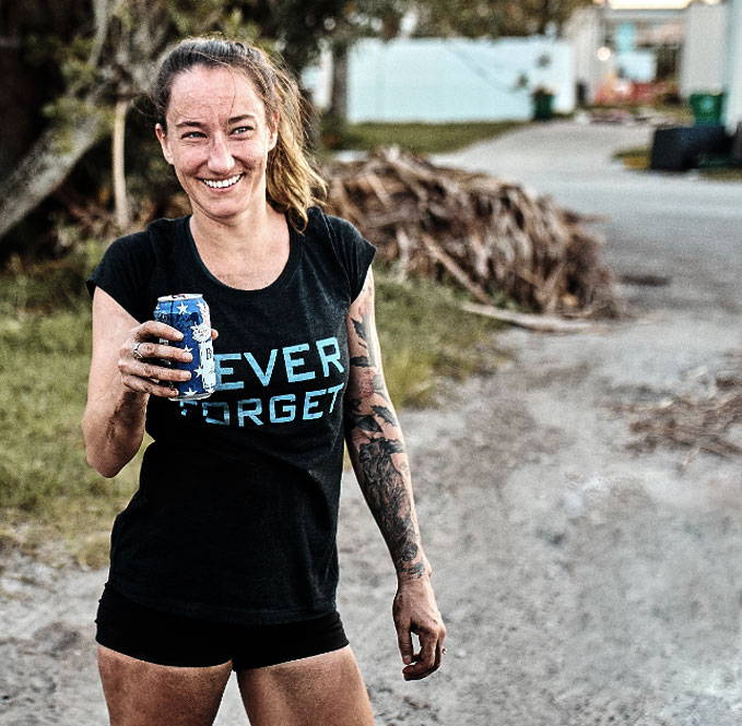 Smiling woman holding a can, wearing a 