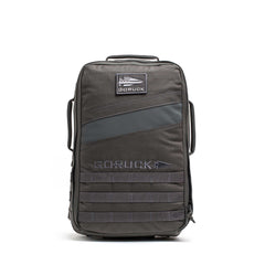 The Rucker 5.0, a black GORUCK rucksack with a front patch and multiple handles, designed for rucking, stands upright on a white background.