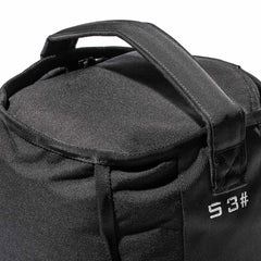 Close-up of a GORUCK Sand Kettlebell - 53LB (24KG), a black fabric bag with two handles and white text "S3" on the side, crafted for endurance and perfect for portable kettlebell workouts.